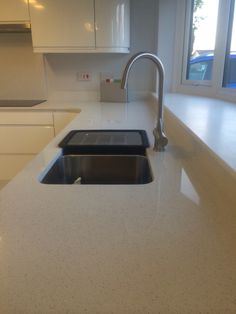 a kitchen counter top with a sink and faucet in the middle of it