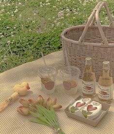 a picnic table with food and condiments on it in front of a basket