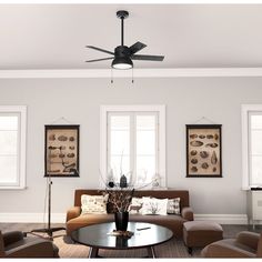 a living room with couches, chairs and a ceiling fan in the middle of it