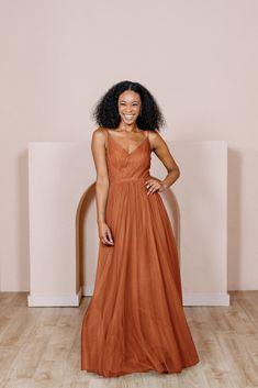 a woman in an orange dress posing for the camera