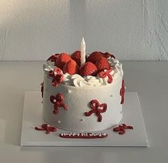 a white cake topped with strawberries and icing