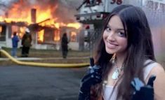 a woman standing in front of a fire