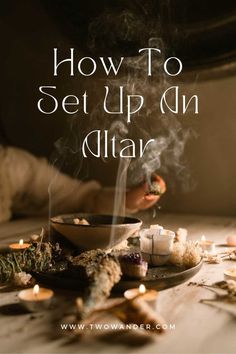 a bowl filled with tea lights on top of a table next to candles and herbs