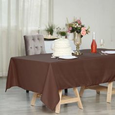 a table with a cake and wine bottles on it in the middle of a room