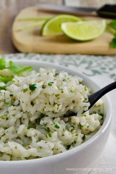 a white bowl filled with rice and garnished with cilantro