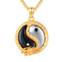 a gold and black yin yang pendant on a chain