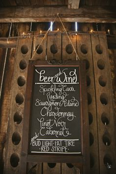 a sign hanging from the side of a wooden structure that says beer and wine on it