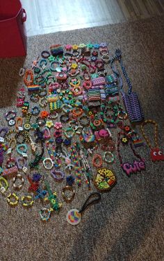 a pile of assorted jewelry on the floor next to a red trash can and bin