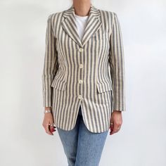 Beautiful vintage blazer in grey and calm yellow vertical stripes. It has a semi fitted shape, shoulder pads, two front pockets with flaps and four front buttons. It is made from linen like viscose mix fabric and comes fully lined. Classy and stylish, perfect with spring/summer outfits! Made by Miss Coral in England. 50% polyester, 50% viscose. 100% polyester lining. Labelled as size 10UK, 36EUR. Measurements when laid flat are: Pit to pit: 50cm Waist: 44cm Hips: 52cm Length: 73cm Shoulders leng Striped Blazer With Pockets And Lapel Collar, Striped Fitted Blazer With Pockets, Fitted Striped Blazer With Pockets, Striped Button-up Blazer For Work, Fitted Blazer With Vertical Stripes For Spring, Spring Fitted Blazer With Vertical Stripes, Fitted Spring Blazer With Vertical Stripes, Fitted Vertical Stripes Spring Blazer, Tailored Striped Linen Blazer