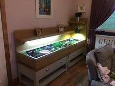 a living room filled with furniture and a fish tank on top of a table next to a window