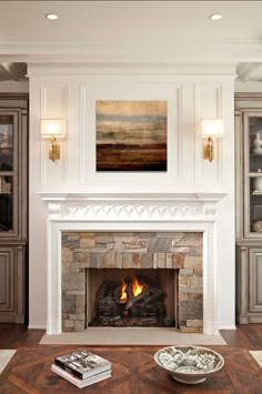 a fire place with a painting on the wall above it