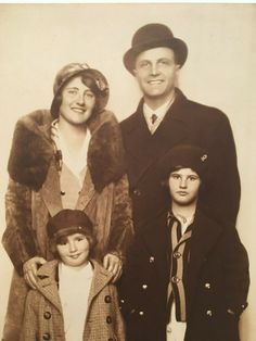 an old black and white photo of two men, one woman and the other child