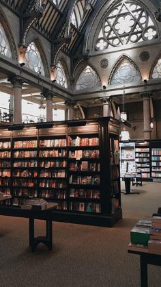 the inside of a library with many books on tables