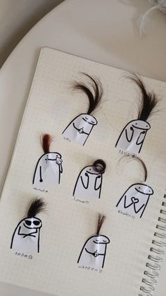 an open notebook with drawings of hair and scissors