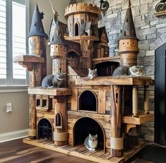 a cat house made out of wooden pallets with cats sitting on top of it