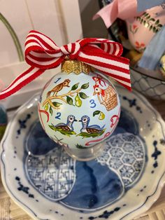 a glass ornament with a red bow on it sitting on top of a plate