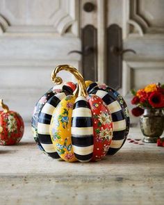 three decorative pumpkins sitting on top of a table