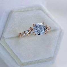 a blue diamond ring sitting on top of a white cloth