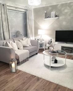 a living room filled with furniture and a flat screen tv on top of a wooden floor