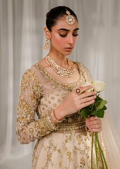 a woman in a bridal gown holding a flower