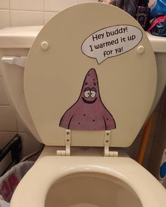 a toilet with a cartoon on the lid and an ad above it that says hey buddy i wannad it up for ya