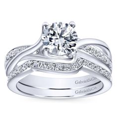 an 18k white gold engagement ring set with round diamonds on the band and shoulders