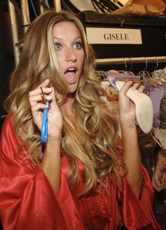 a woman in a red robe holding a pair of scissors