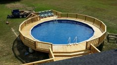 an above ground swimming pool with deck and stairs