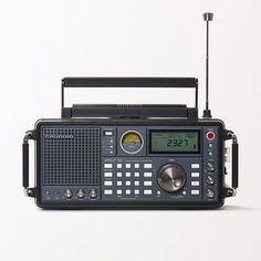 an old fashioned radio is sitting on a white surface, with the time displayed in front of it