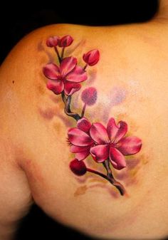 the back of a woman's shoulder with pink flowers on her left arm and chest