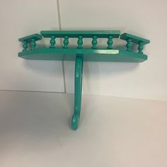 a green coat rack on a white wall