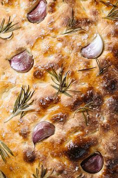 an onion and rosemary quiche is shown on a baking sheet with sprigs