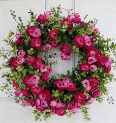 a wreath with pink flowers and green leaves