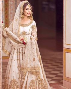 a woman in a white and gold bridal gown