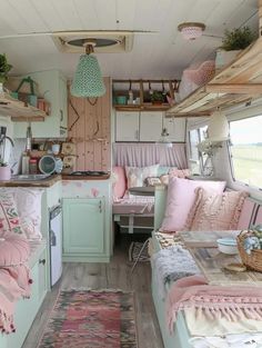 the interior of an rv is decorated in pastel pinks and greens, with lots of storage