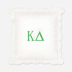 a white pillow with the letter k and green letters on it's front side