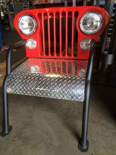 the front end of a red jeep with two lights on it's headlamps