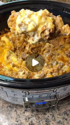 a crock pot filled with cheese and meat