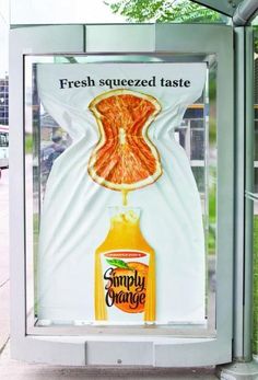 an advertisement for simply orange juice on the side of a bus stop