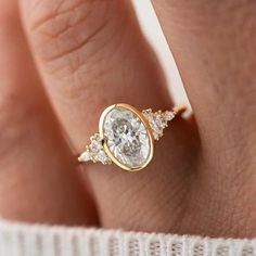 a woman's hand with a diamond ring on top of her finger and an engagement band