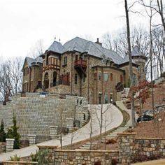 a large brick house with a stone wall and steps leading up to it's entrance