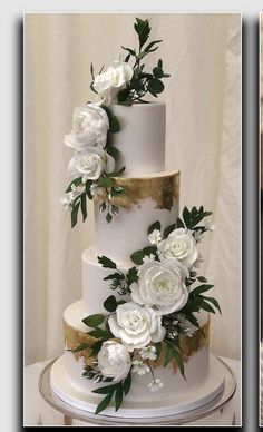 a white and gold wedding cake with flowers on top