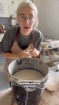 a woman in glasses is making something out of an old bucket