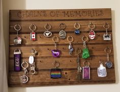 a wooden sign with lots of key chains hanging on it's sides and the words charms of memories