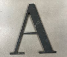 a metal letter sitting on top of a white table