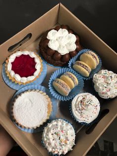 a box filled with different types of cupcakes