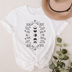 Description: Floral Moon Shirt, Starry Night Shirt, Wildflower Shirt, Plant Lover Shirt, Botanical Shirt, Flower Shirt, Astrology Shirt Product: * Unisex T-shirts 100% combed and ring-spun cotton, Soft and Comfy * Heather colors are 52% combed and ring-spun cotton, 48% polyester * Athletic and Black Heather are 90% combed and ring-spun cotton, 10% polyester * Heather Prism colors are 99% combed and ring-spun cotton, 1% polyester Size: Shirts are true-to-size. Unisex size will be a looser fit. You can size down if you want a tighter fit. How To Order: 1. Select T-Shirt Color. 2. Select T-Shirt Size. 3. Click Add To Cart. 4. Select Quantity in Cart. 5. Proceed to Checkout. ★Please take your time to read our shop policies before purchasing. ★By making a purchase, you are agreeing to our shop White Moon Print T-shirt For Summer, White Graphic Tee With Moon Print, Bohemian White Shirt With Graphic Print, White Bohemian Shirt With Graphic Print, Astrology Shirt, Wildflower Shirt, Floral Moon, Moon Shirt, Botanical Shirt