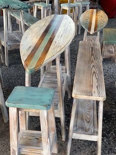 several wooden stools and tables sitting on gravel