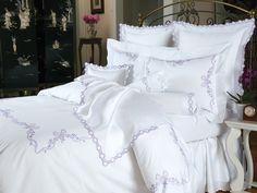 a bed with white and purple comforters in a bedroom