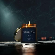 a candle that is sitting on a table next to a wall with the words celestial glow written on it